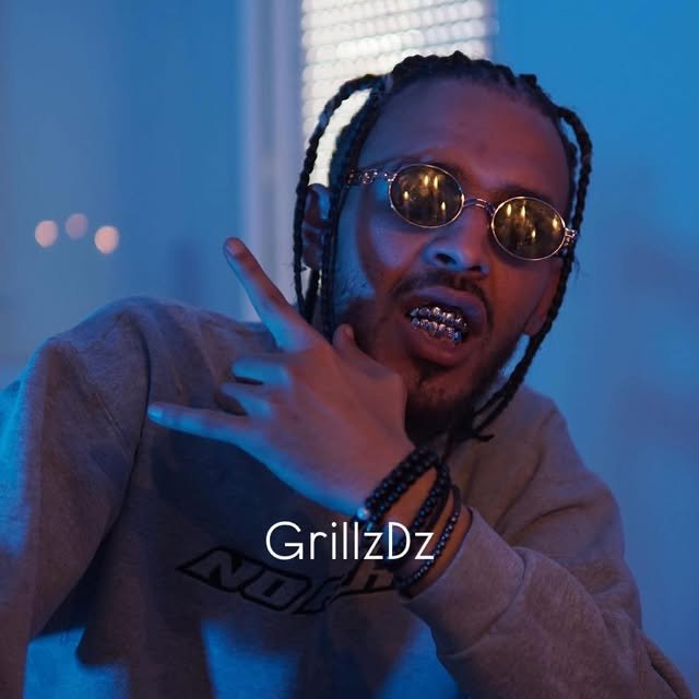 Client avec lunettes et grillz, main en signe